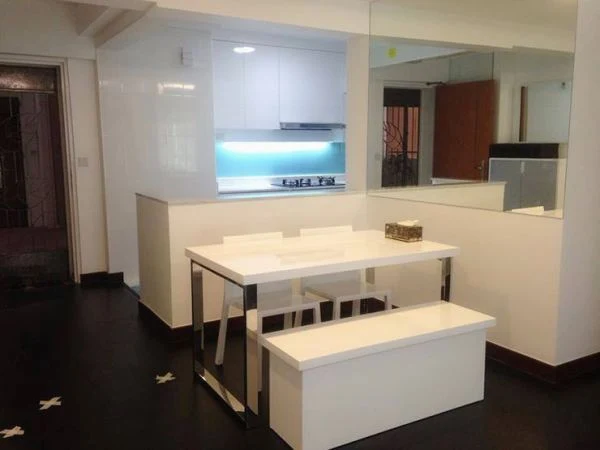 White kitchen cabinets and a tiled floor around a compact island