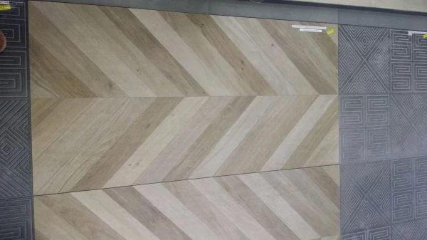Wood-effect tiles arranged in a chevron pattern on a material display